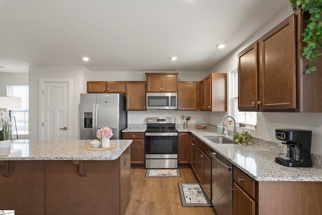 kitchen with a wealth of natural light, light wood-type flooring, sink, and appliances with stainless steel finishes