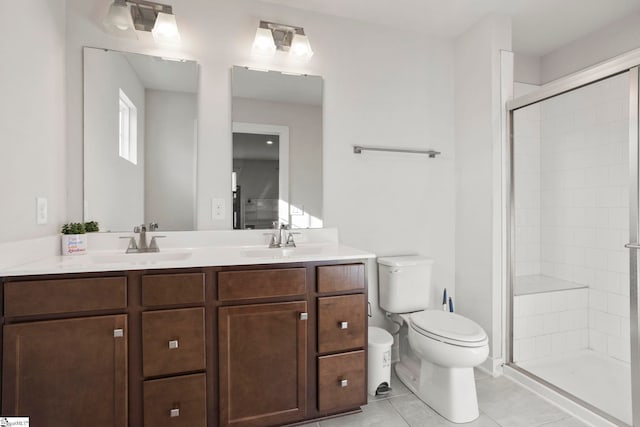 bathroom featuring tile patterned flooring, vanity, toilet, and a shower with door