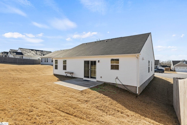 back of property with a yard and a patio