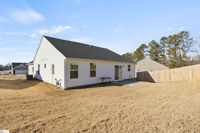 back of house featuring central AC unit, a patio area, and a yard