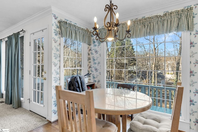 dining area featuring hardwood / wood-style flooring, an inviting chandelier, and ornamental molding