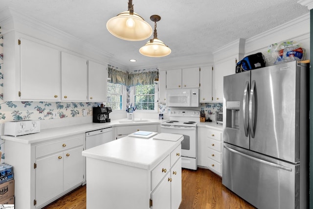 kitchen featuring white appliances, a kitchen island, sink, white cabinetry, and hanging light fixtures