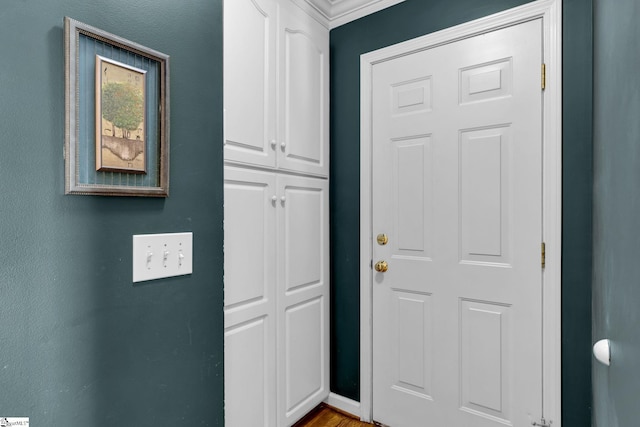 doorway to outside with hardwood / wood-style flooring and crown molding