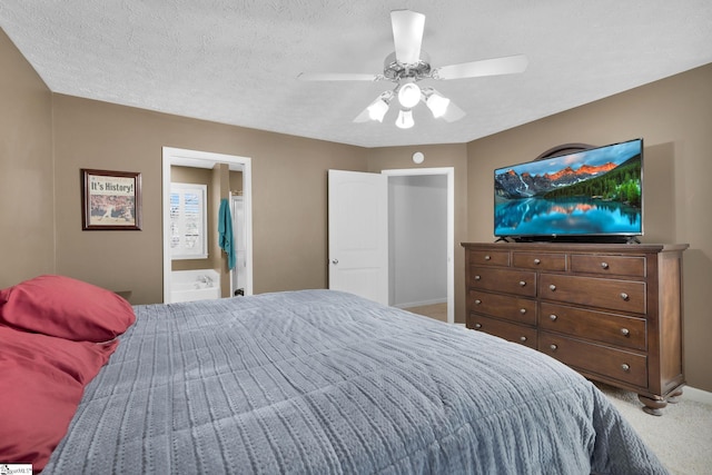 bedroom featuring carpet, a textured ceiling, ensuite bathroom, and ceiling fan