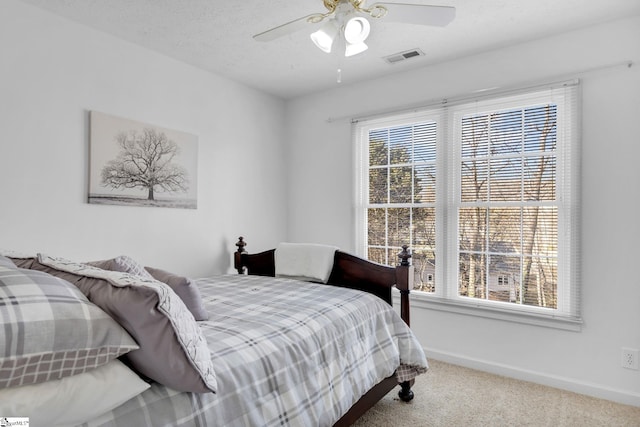 bedroom featuring carpet flooring, a textured ceiling, and ceiling fan