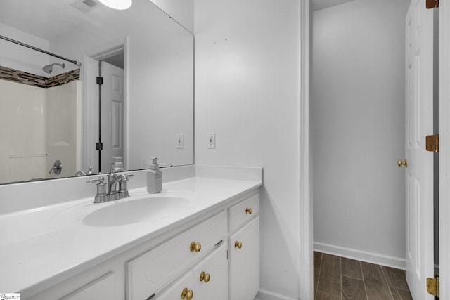 bathroom featuring hardwood / wood-style floors, vanity, and walk in shower