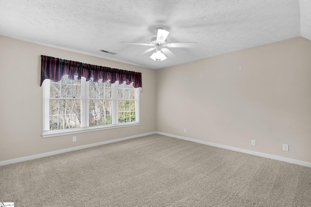 empty room with a textured ceiling, carpet floors, vaulted ceiling, and ceiling fan