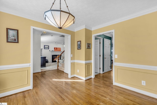 dining room featuring crown molding, hardwood / wood-style floors, and a textured ceiling