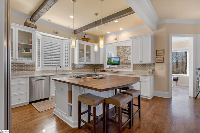 kitchen featuring wood counters, appliances with stainless steel finishes, a center island, and white cabinets