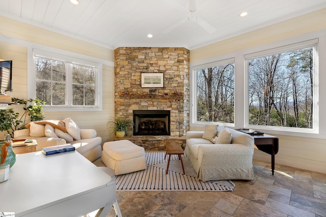 living room featuring plenty of natural light, ceiling fan, and a fireplace