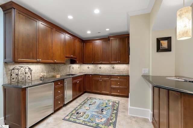 kitchen with backsplash, dark stone counters, pendant lighting, fridge, and light tile patterned flooring