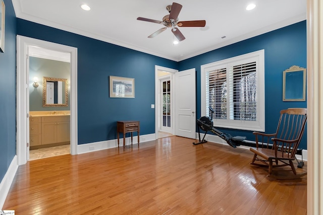 workout room with ceiling fan, light wood-type flooring, and crown molding