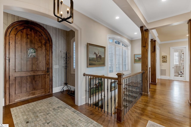 foyer with a chandelier, hardwood / wood-style flooring, and ornamental molding