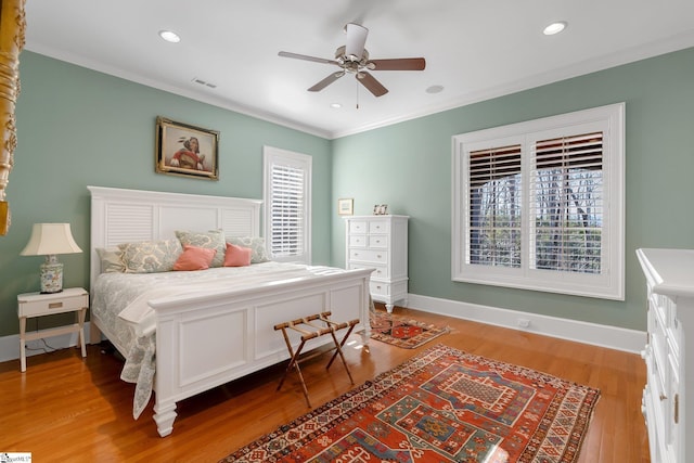 bedroom with hardwood / wood-style floors, ceiling fan, and ornamental molding