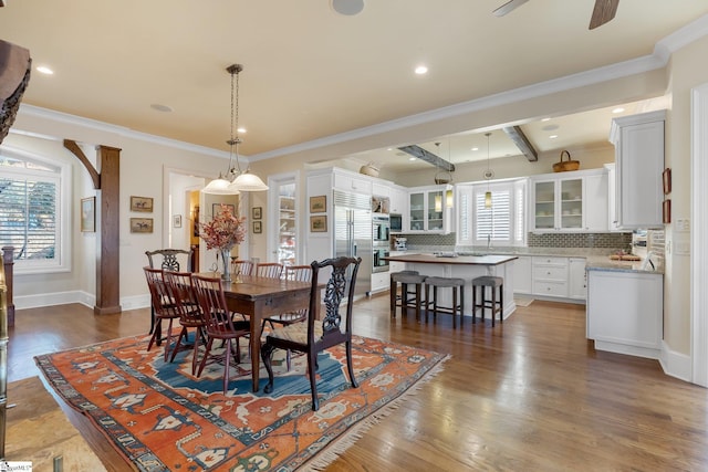 dining space featuring beam ceiling, dark hardwood / wood-style floors, and ornamental molding