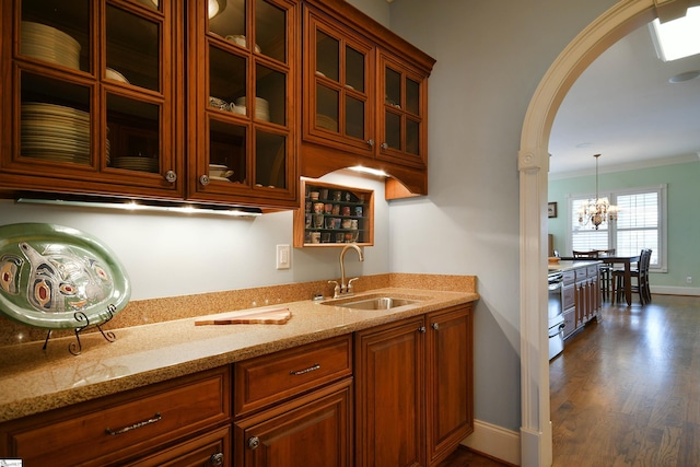 kitchen with pendant lighting, dark wood-type flooring, sink, a notable chandelier, and light stone counters