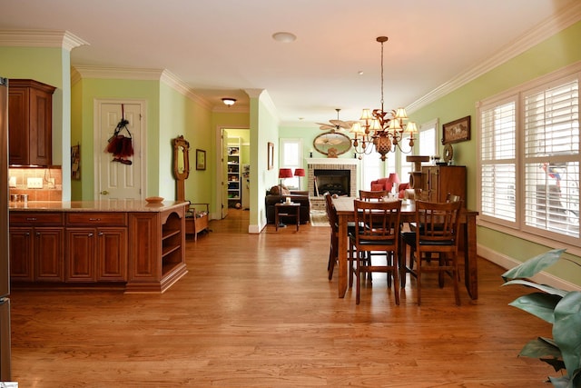 dining area featuring ornamental molding and light hardwood / wood-style flooring