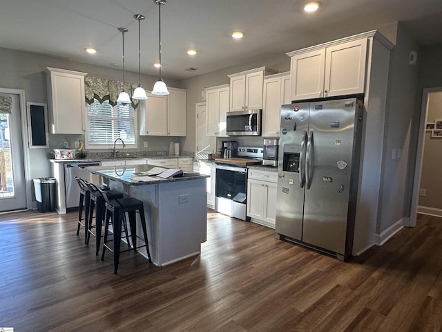 kitchen with white cabinetry, a center island, pendant lighting, and appliances with stainless steel finishes