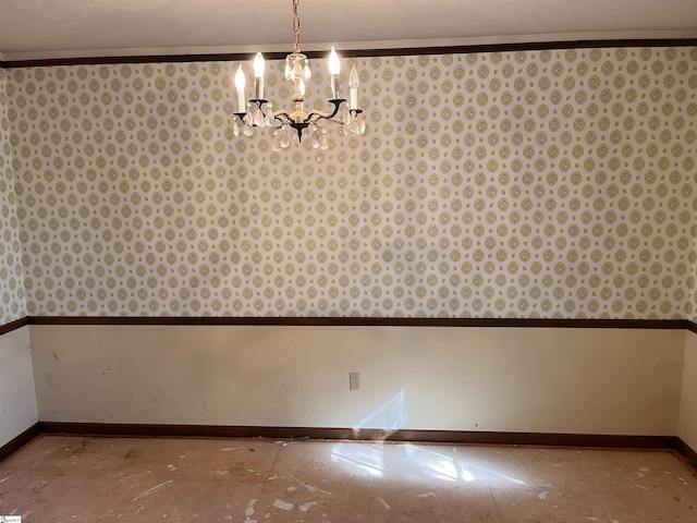 unfurnished dining area featuring crown molding and a chandelier