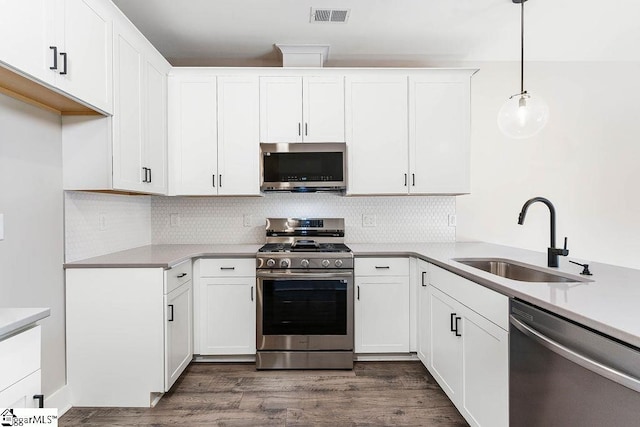 kitchen featuring stainless steel appliances, sink, hanging light fixtures, and white cabinets