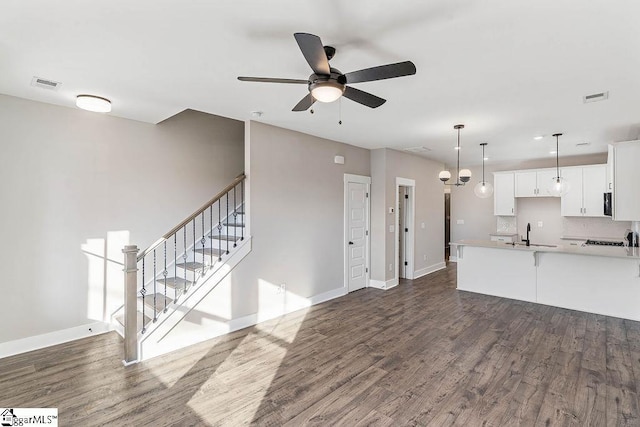 kitchen with sink, decorative light fixtures, dark hardwood / wood-style flooring, white cabinets, and backsplash