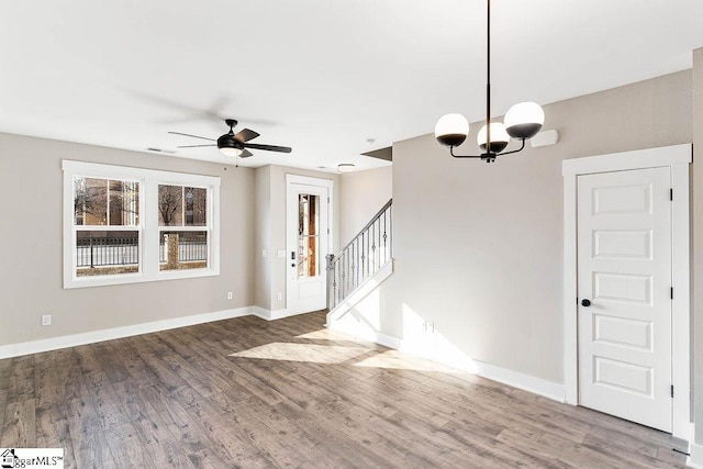 interior space with ceiling fan with notable chandelier and hardwood / wood-style floors