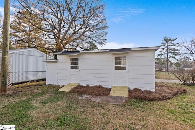 view of side of property featuring an outbuilding and a yard