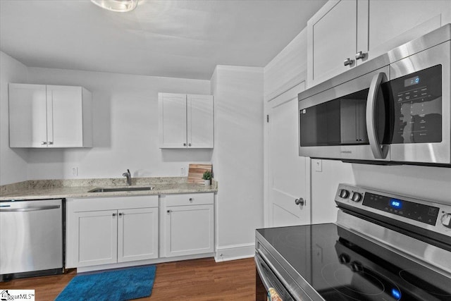 kitchen with dark wood-type flooring, sink, white cabinets, and stainless steel appliances