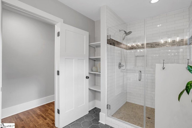 bathroom featuring a shower with door and hardwood / wood-style flooring