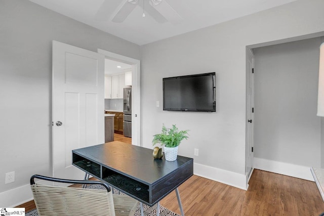 home office with light wood-type flooring and ceiling fan