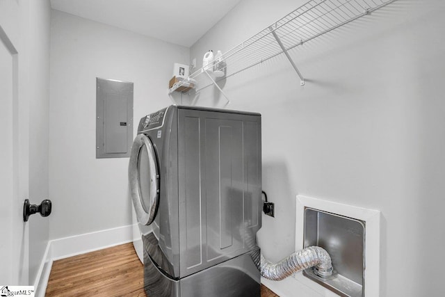 clothes washing area featuring electric dryer hookup, electric panel, and hardwood / wood-style flooring