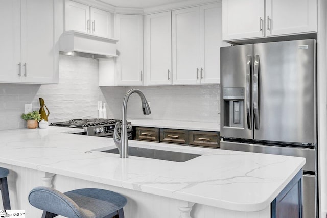 kitchen with custom exhaust hood, white cabinets, tasteful backsplash, a kitchen bar, and stainless steel fridge with ice dispenser