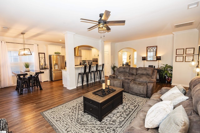 living room with dark hardwood / wood-style floors, ornate columns, ceiling fan, and crown molding