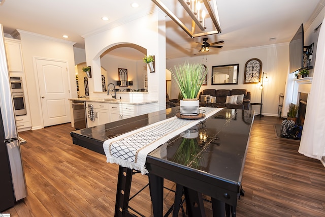 dining space featuring crown molding, dark hardwood / wood-style flooring, and ceiling fan