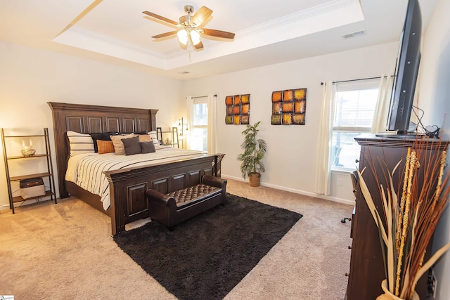 bedroom featuring a raised ceiling, light carpet, crown molding, and ceiling fan