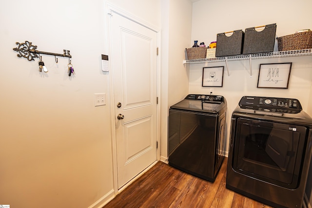 washroom featuring washing machine and dryer and dark wood-type flooring