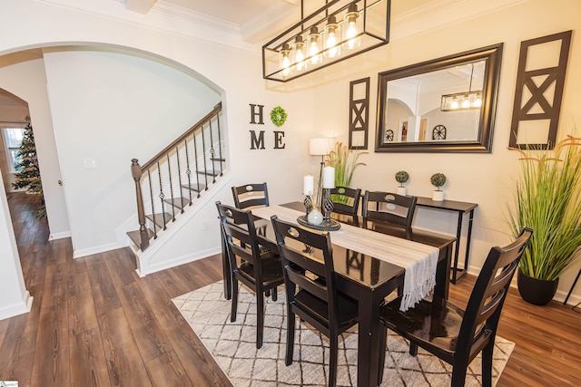 dining space with crown molding and dark wood-type flooring