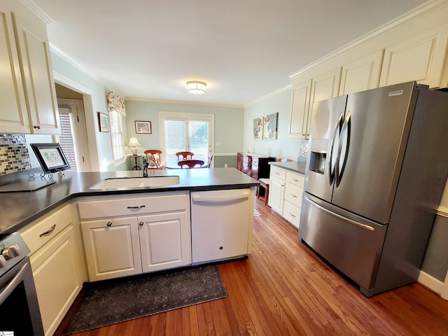 kitchen with white cabinetry, dishwasher, sink, stainless steel fridge with ice dispenser, and kitchen peninsula