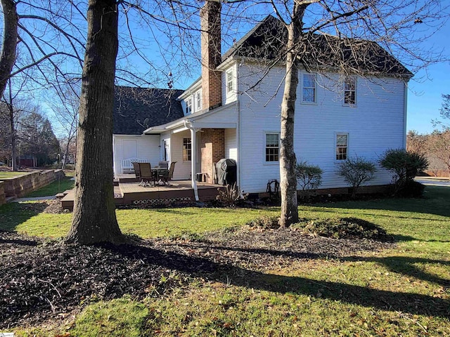 rear view of property with a yard and a wooden deck