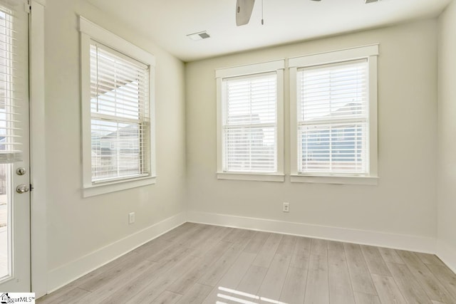 empty room with a wealth of natural light and light wood-type flooring