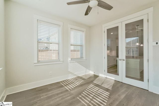 unfurnished sunroom featuring ceiling fan and french doors