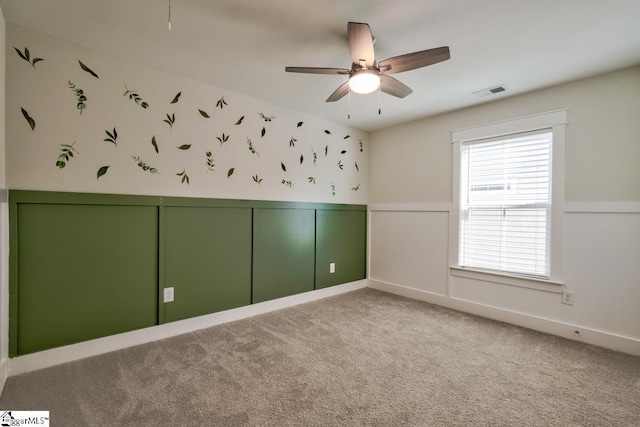 carpeted spare room featuring ceiling fan