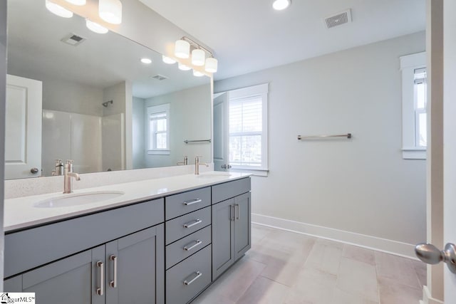 bathroom with a shower, vanity, and tile patterned flooring