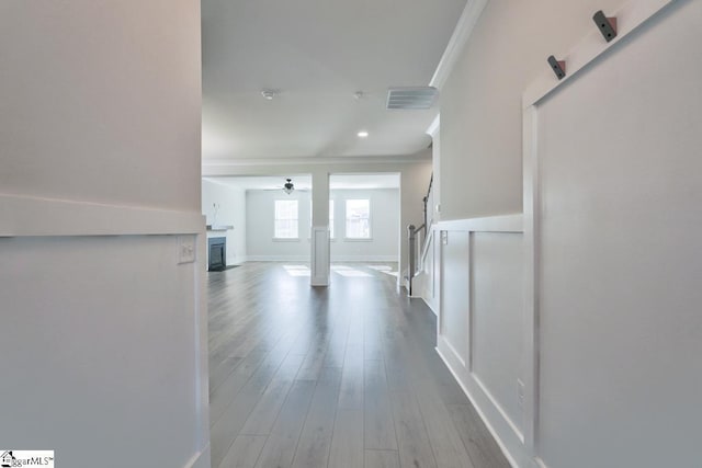 corridor featuring wood-type flooring and ornamental molding