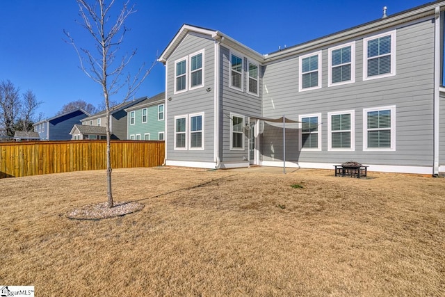 rear view of house featuring a lawn and an outdoor fire pit