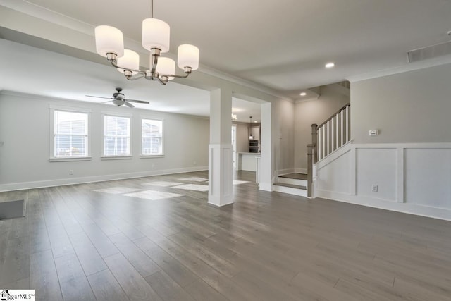 unfurnished living room featuring dark hardwood / wood-style flooring, ceiling fan with notable chandelier, and ornamental molding