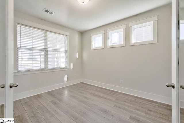 unfurnished room featuring french doors and light hardwood / wood-style flooring