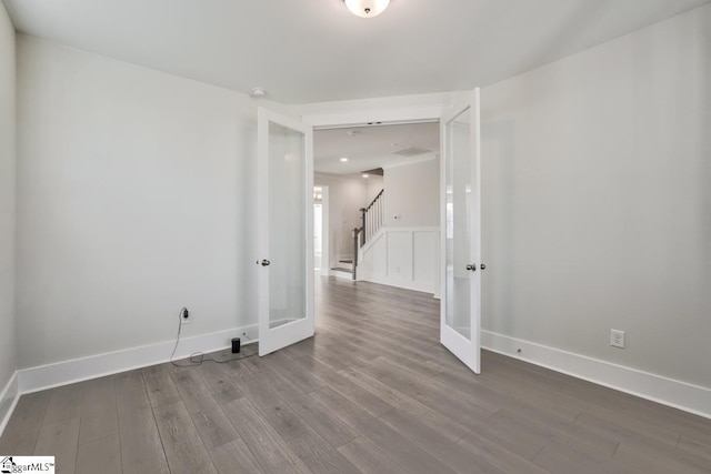 spare room with french doors and hardwood / wood-style flooring