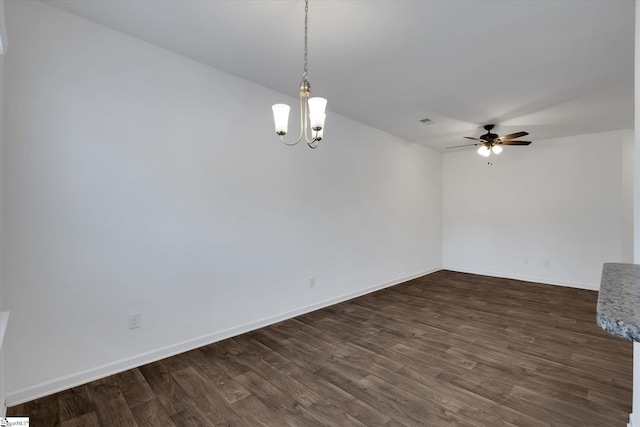 empty room featuring ceiling fan with notable chandelier and dark hardwood / wood-style flooring