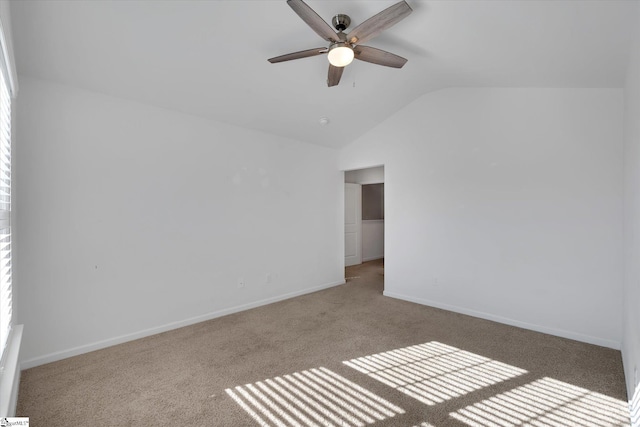 spare room with ceiling fan, light carpet, and lofted ceiling